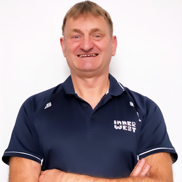  Personal trainer Michael standing with arms folded and smiling wearing a navy blue shirt branded with Inner West Aquatics logo